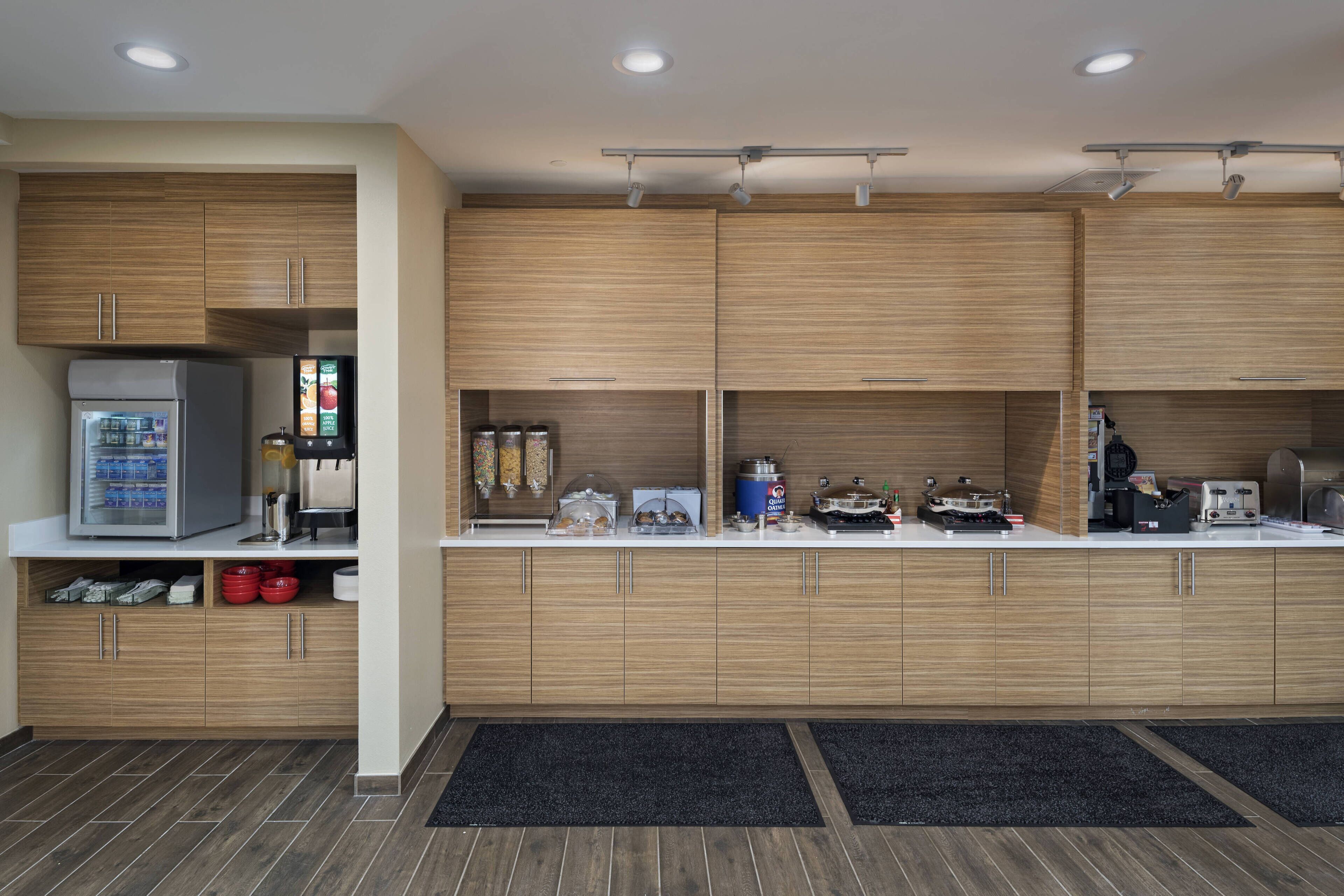 A modern kitchen with wooden cabinets, a refrigerator, and various appliances.