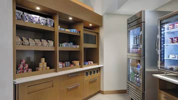 Una kitchenette con armarios de madera, un refrigerador y un microondas.