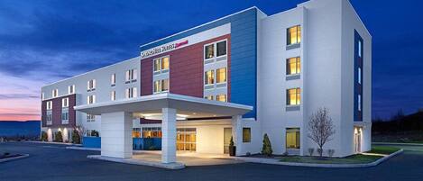 Un hotel moderno con techo plano, entrada cubierta y letrero que indica que es un SpringHill Suites Marriott.