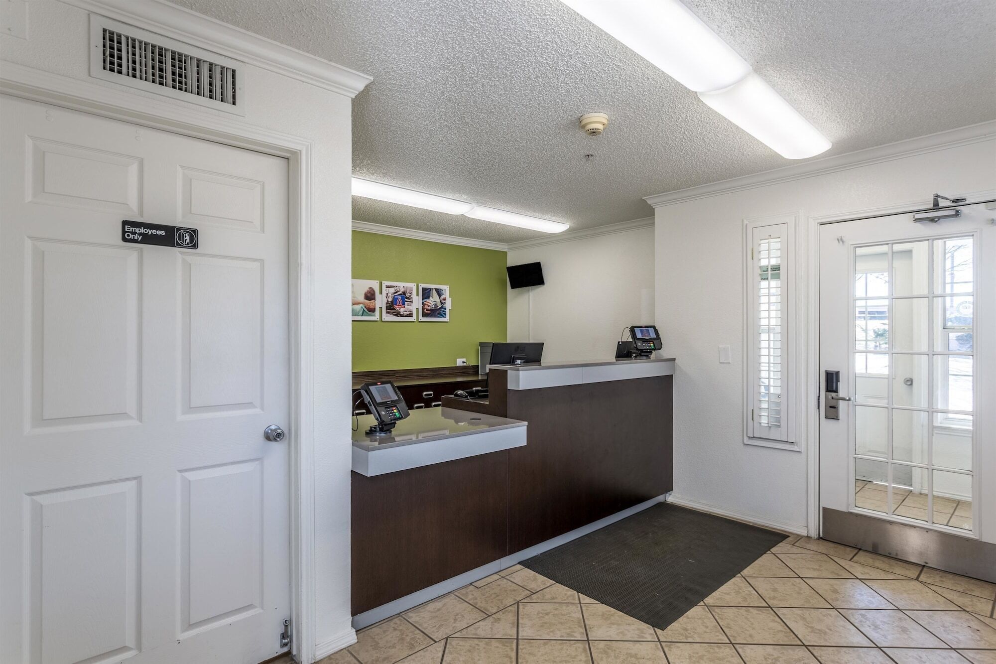 A reception area with a counter, a security camera, and a door marked "Employees Only".