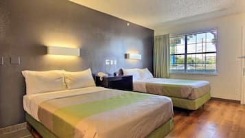 Tabla de planchar con plancha, ropa de cama y despertador