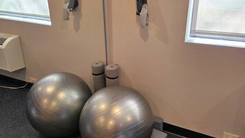 A room with exercise balls, a mirror, and a window.