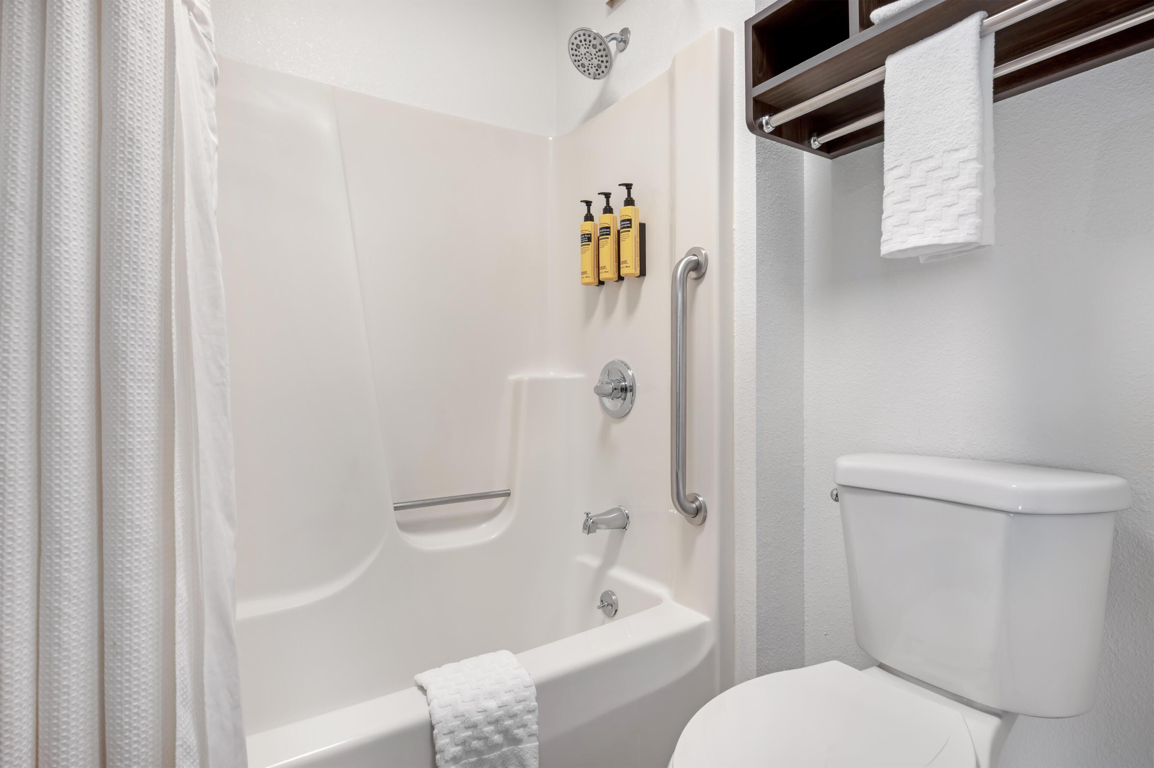 A bathroom with a bathtub, toilet, and shower.