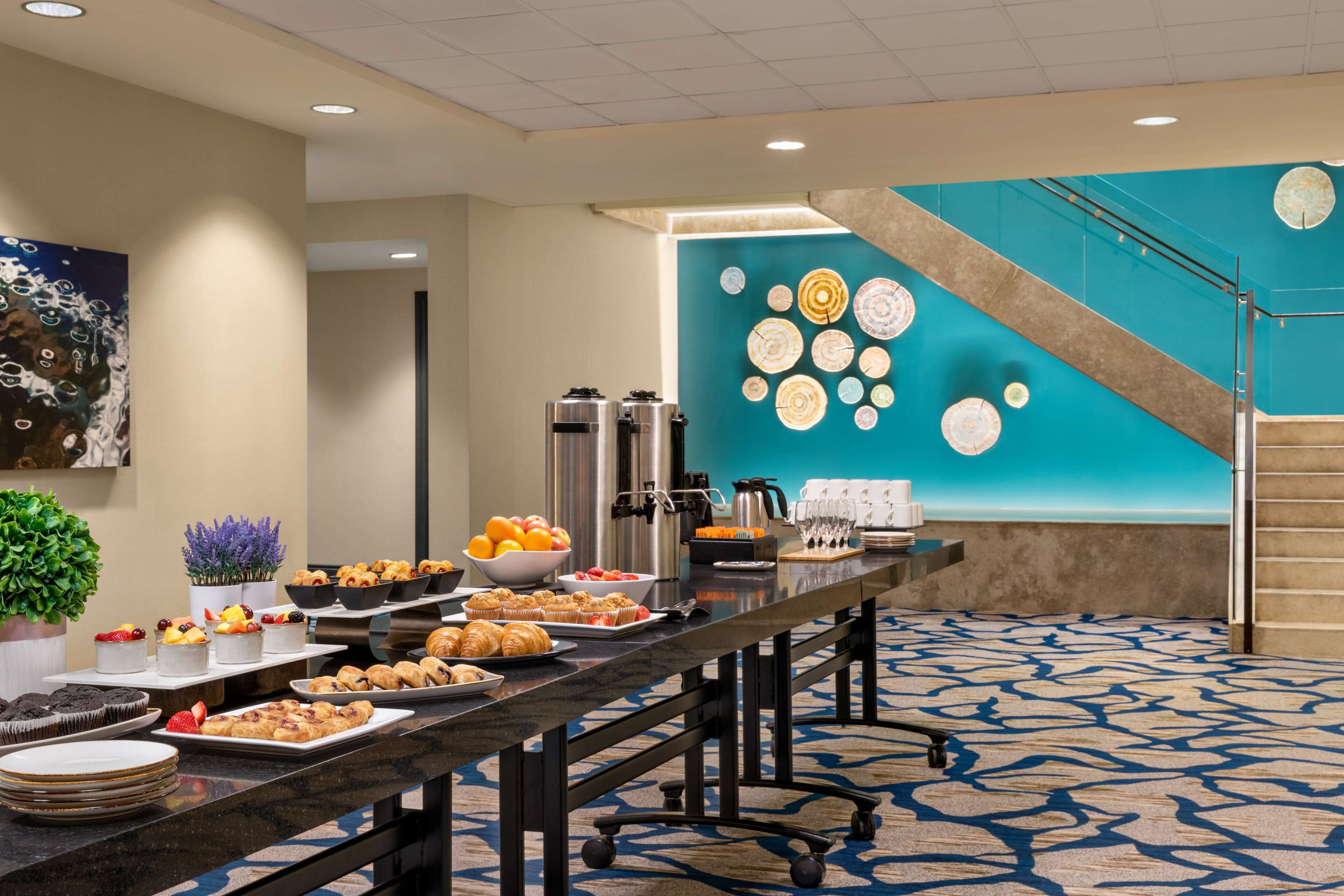 A buffet setup with various food items and a decorative wall with circular patterns.