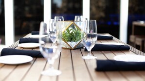 A dining table with plates, glasses, and a decorative centerpiece.