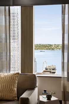 A conference room with a long table, multiple chairs, a large screen, and a framed picture on the wall. at Hilton Motif Seattle