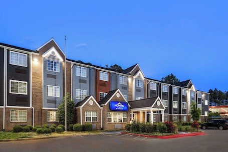 A Microtel by Wyndham hotel with a brick facade, multiple windows, and a parking lot.