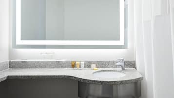 Un baño con encimera de granito, un lavabo y un espejo.