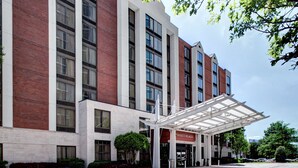 A multi-story hotel with a covered entrance and a brick facade.