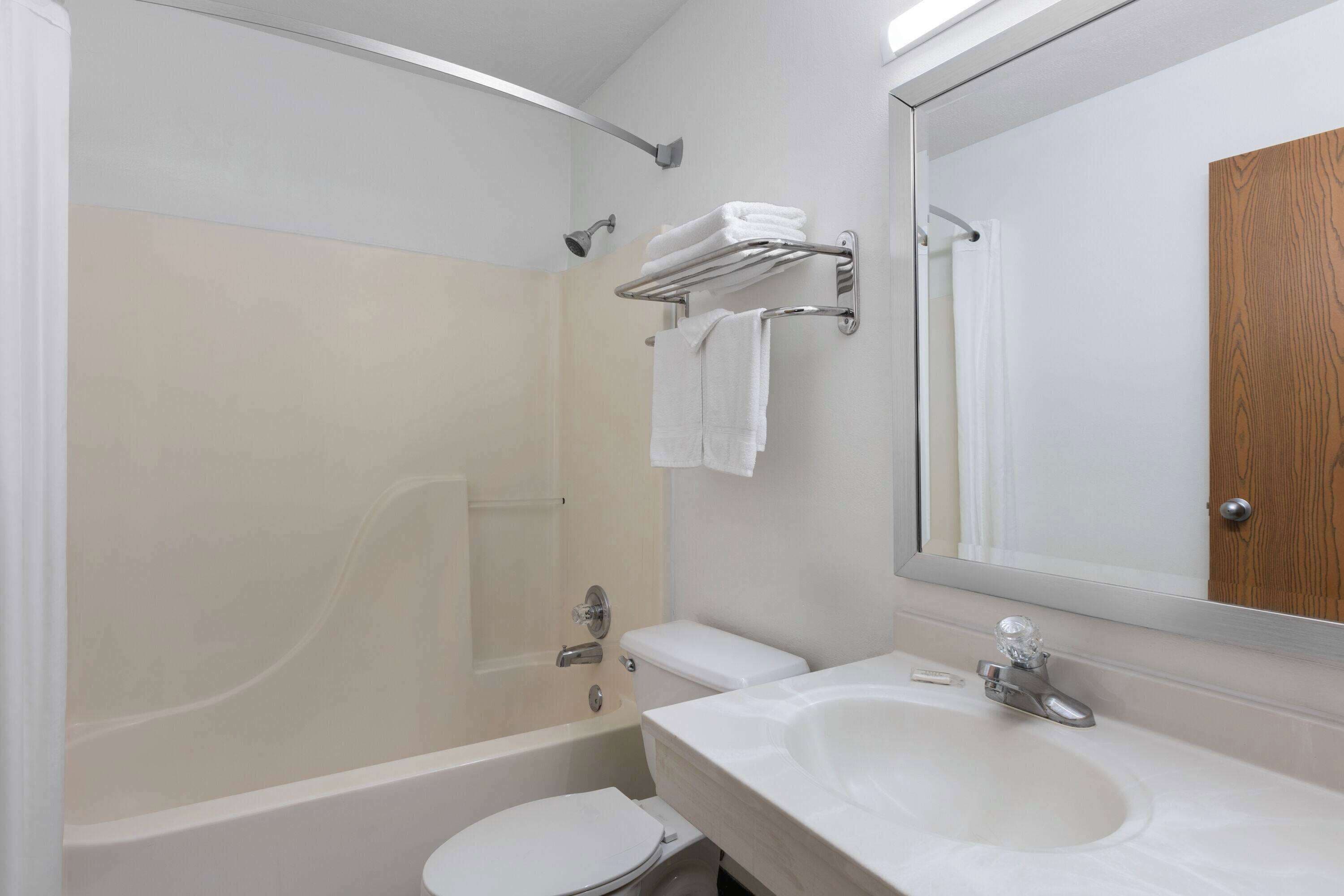 A modern bathroom with a bathtub, toilet, and sink.