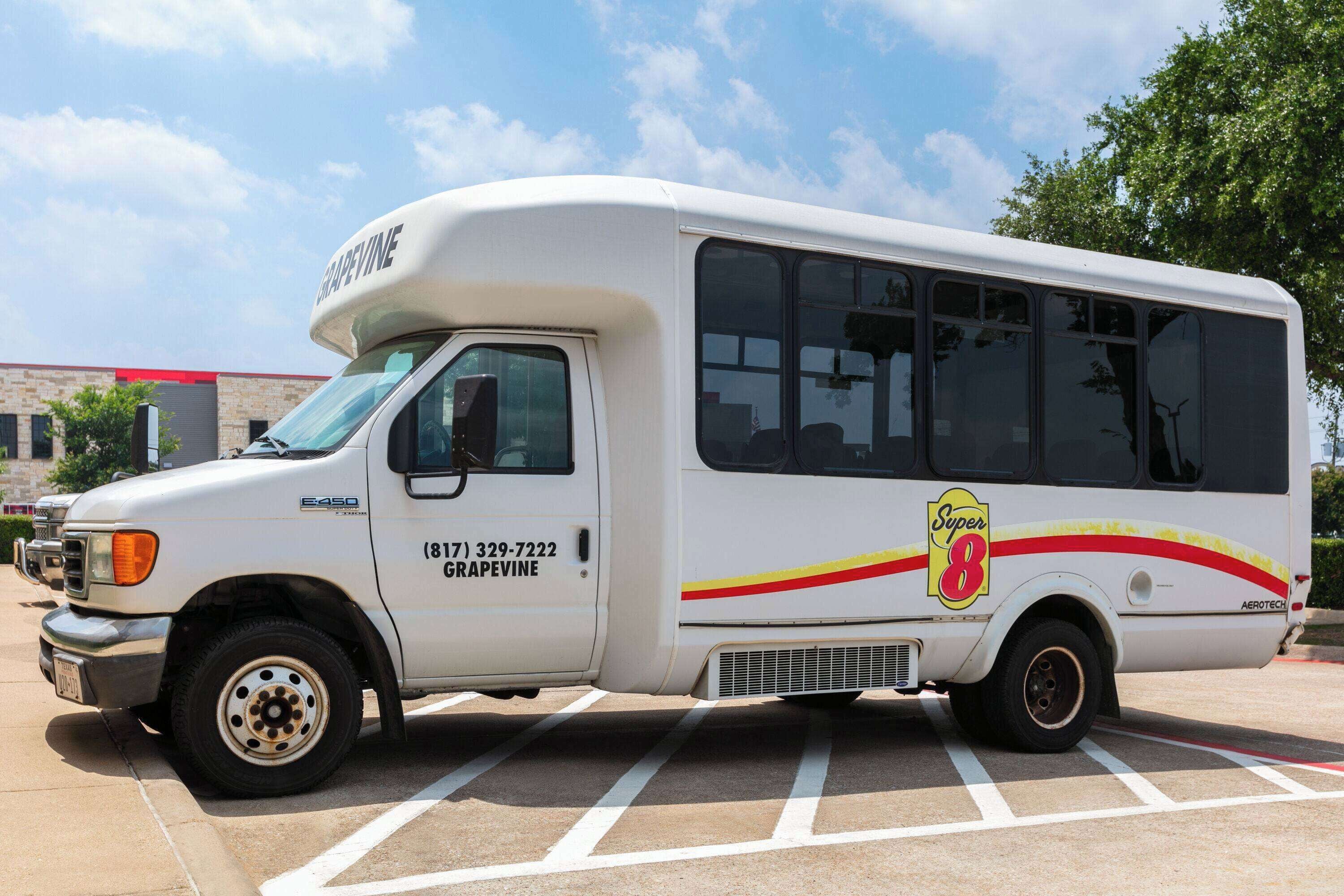 A white van with "GRAPEVINE" and "Super 8" branding parked in a lot.