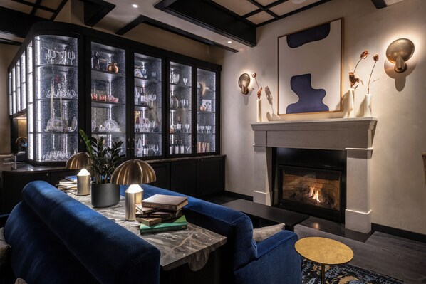 A modern living room with a fireplace, a bookshelf, and a cozy seating area.
