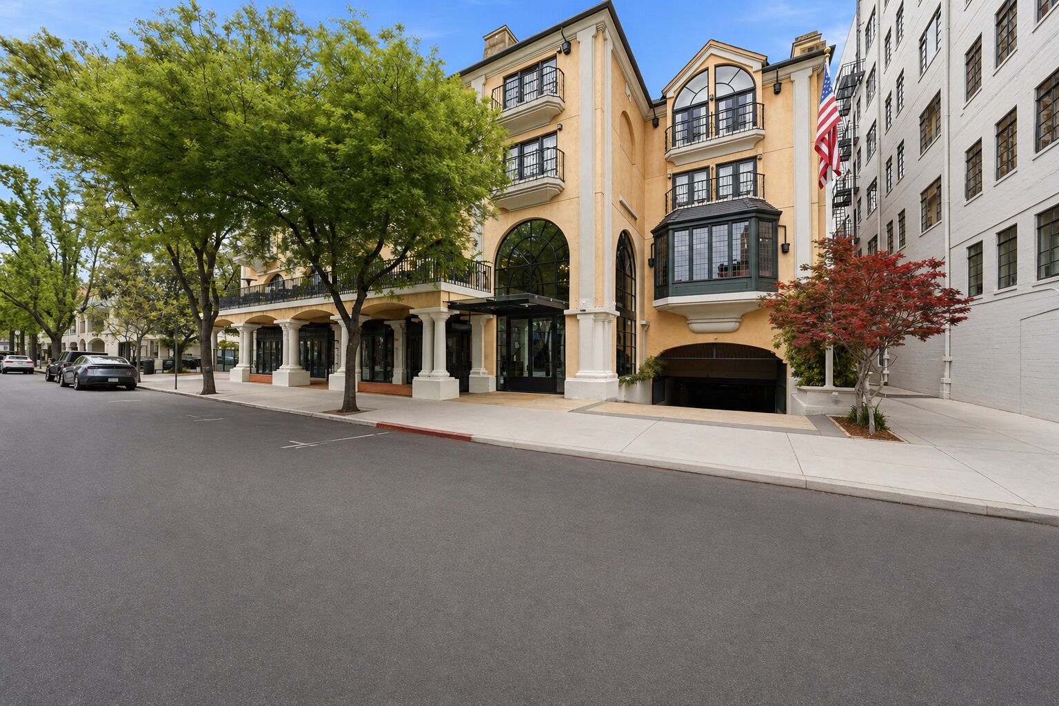 A multi-story hotel with a classic architectural style, featuring a central entrance with a glass facade and a flagpole.
