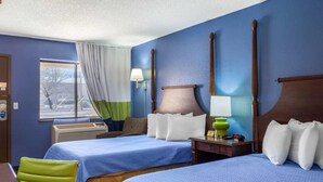 A hotel room with two beds, a window with curtains, a desk with a lamp, and a nightstand with a clock. - Rodeway Inn near Ft Huachuca (Sierra Vista)