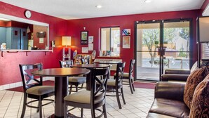 A restaurant with red walls, a clock, and a view of the street. - Rodeway Inn near Ft Huachuca (Sierra Vista)