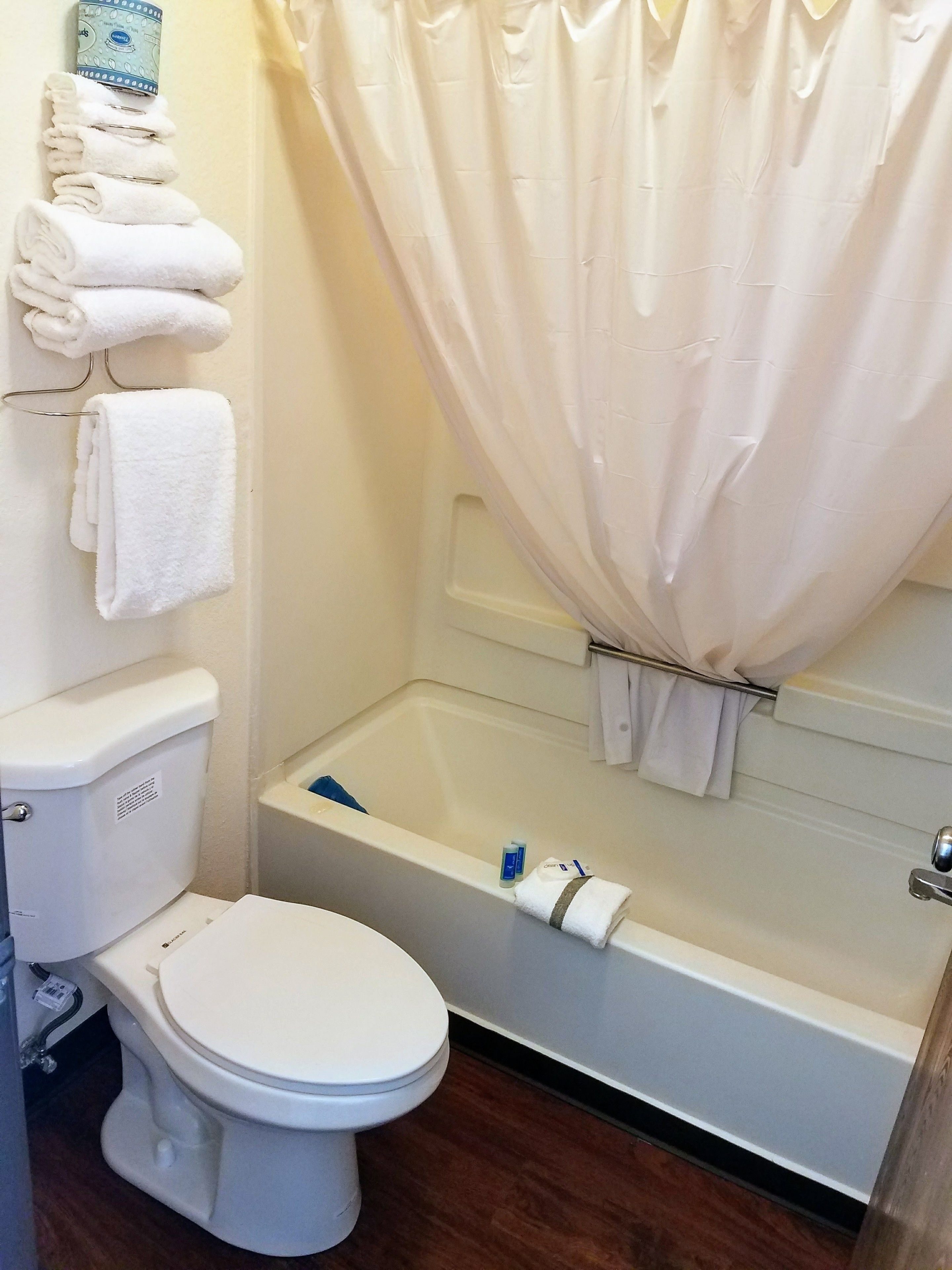 A bathroom with a toilet, a bathtub, and a shower curtain.