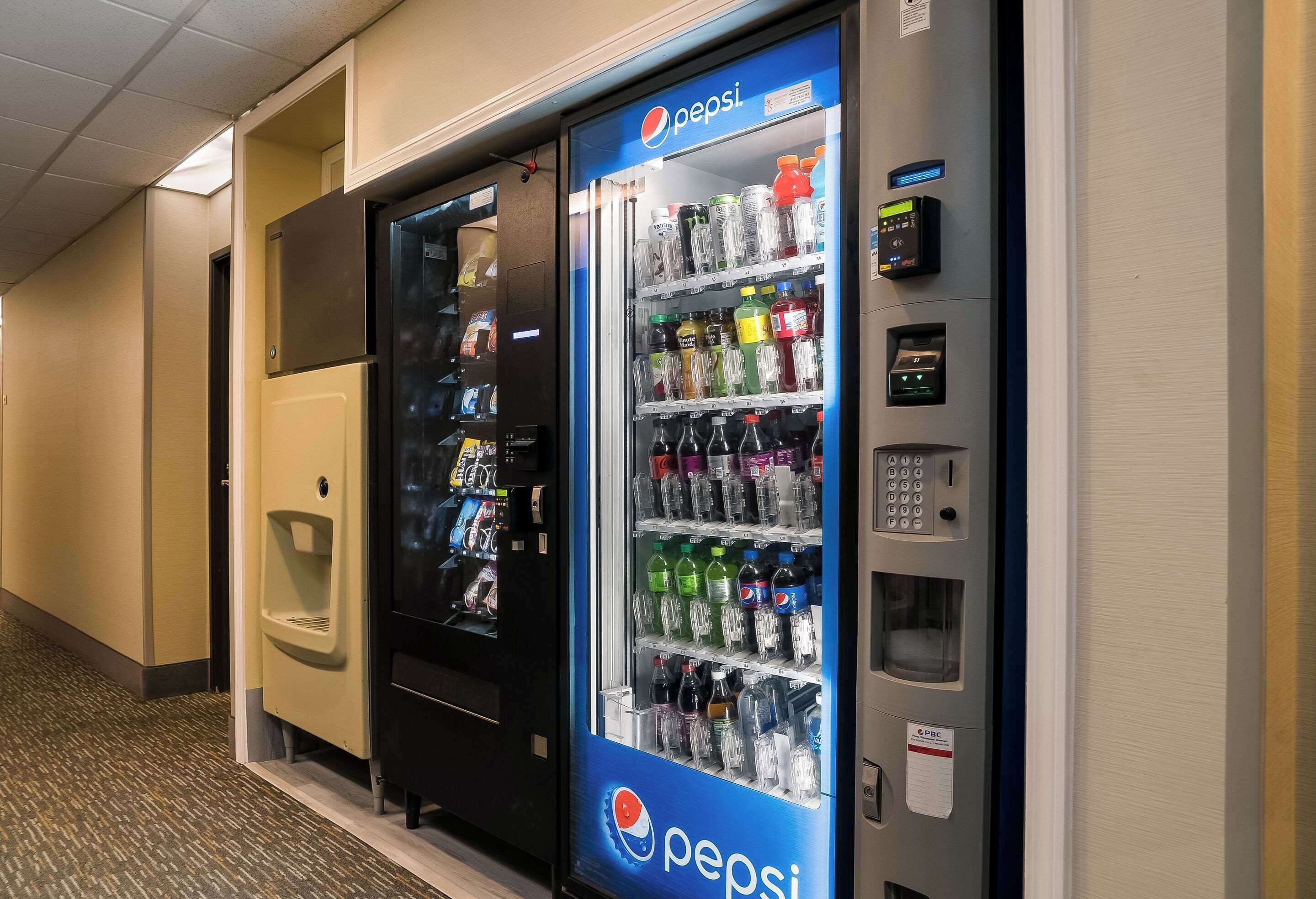 Máquina expendedora con logotipo de Pepsi, repleta de diferentes bebidas.