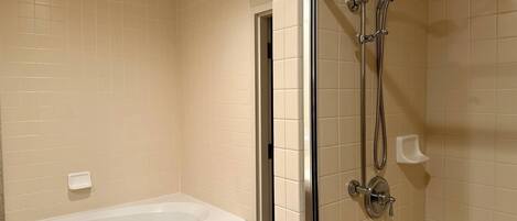 A bathroom with a bathtub and a shower area.