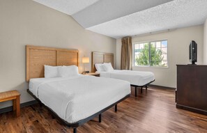 A hotel room with two beds, a desk, a television, and a window with curtains. - Extended Stay America Suites Dallas Plano Parkway (Plano)