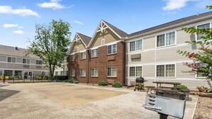 A residential building with a brick facade, multiple windows, and a paved driveway. - Extended Stay America Suites Dallas Plano Parkway (Plano)
