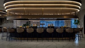 Eine moderne Bar mit kreisförmigem Design, Barhocker und einem Marmorboden.