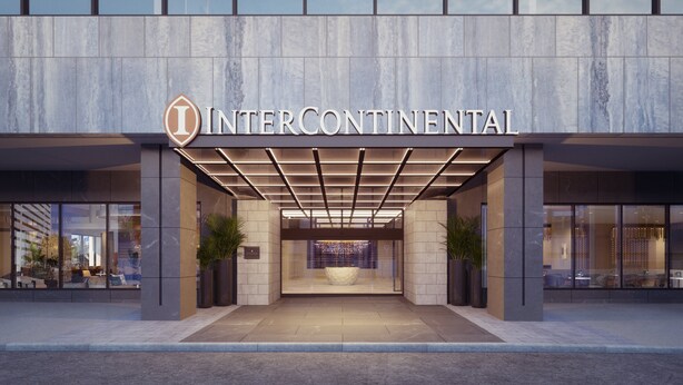 Der Eingangsbereich des Intercontinental Hotels mit modernem Design, einem gut sichtbaren Logo, einem überdachten Bereich und Topfpflanzen.