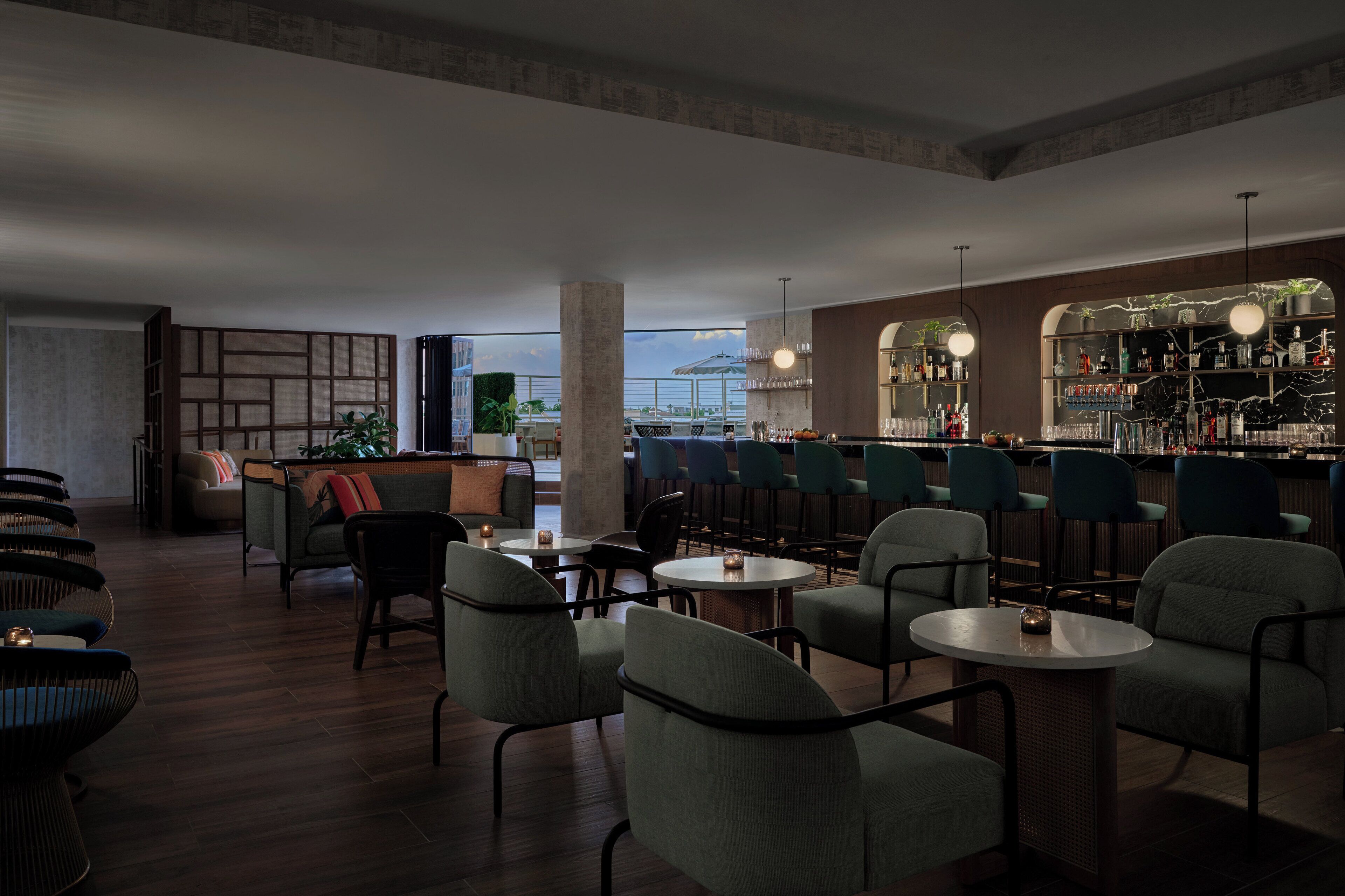 Un espacio moderno de bar con asientos, una barra y vistas al exterior.