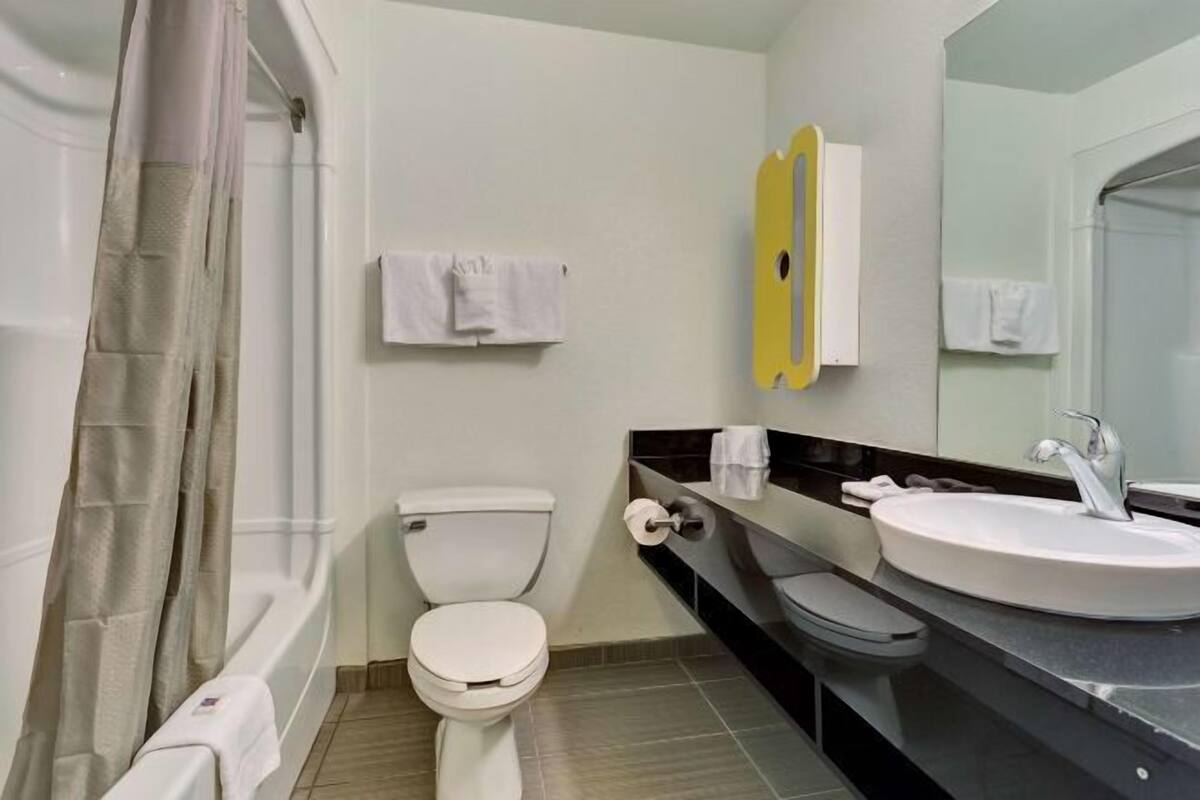 A modern bathroom with a toilet, sink, and shower.