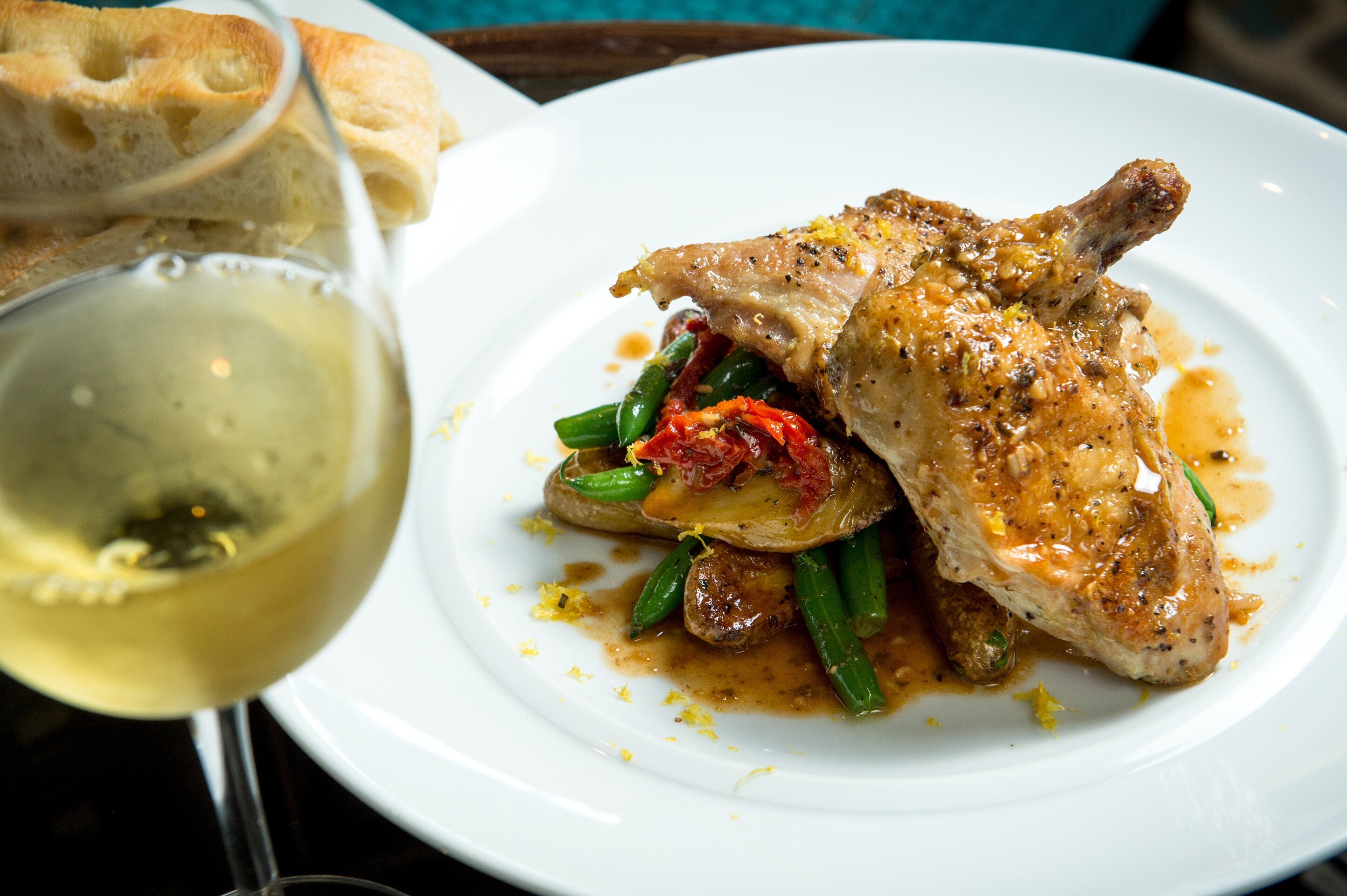 A plate of food with a glass of white wine.
