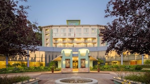 A hotel with a central courtyard, a fountain, and a well-lit entrance.