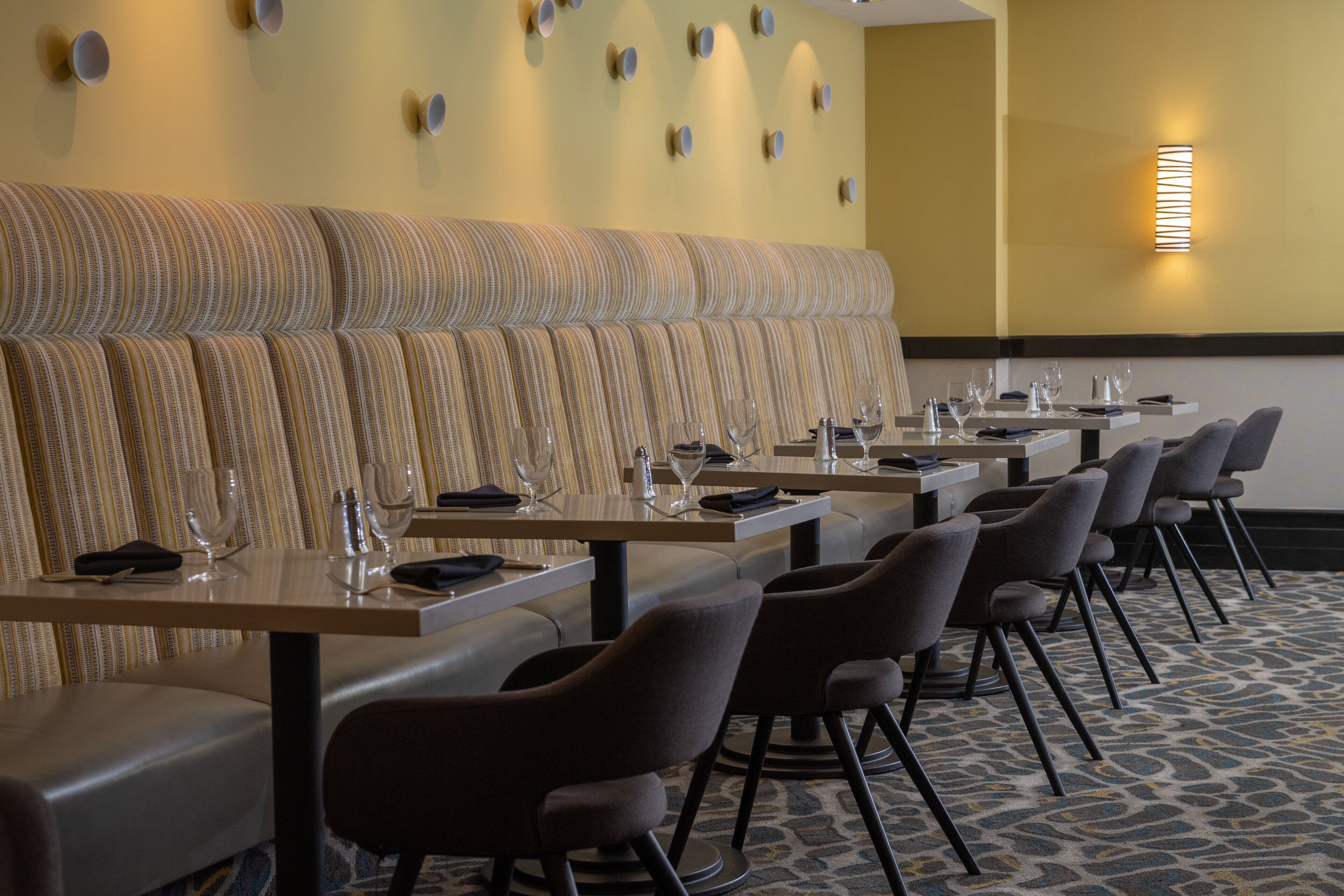 Un restaurant doté d’un long comptoir, de plusieurs tables et de chaises.