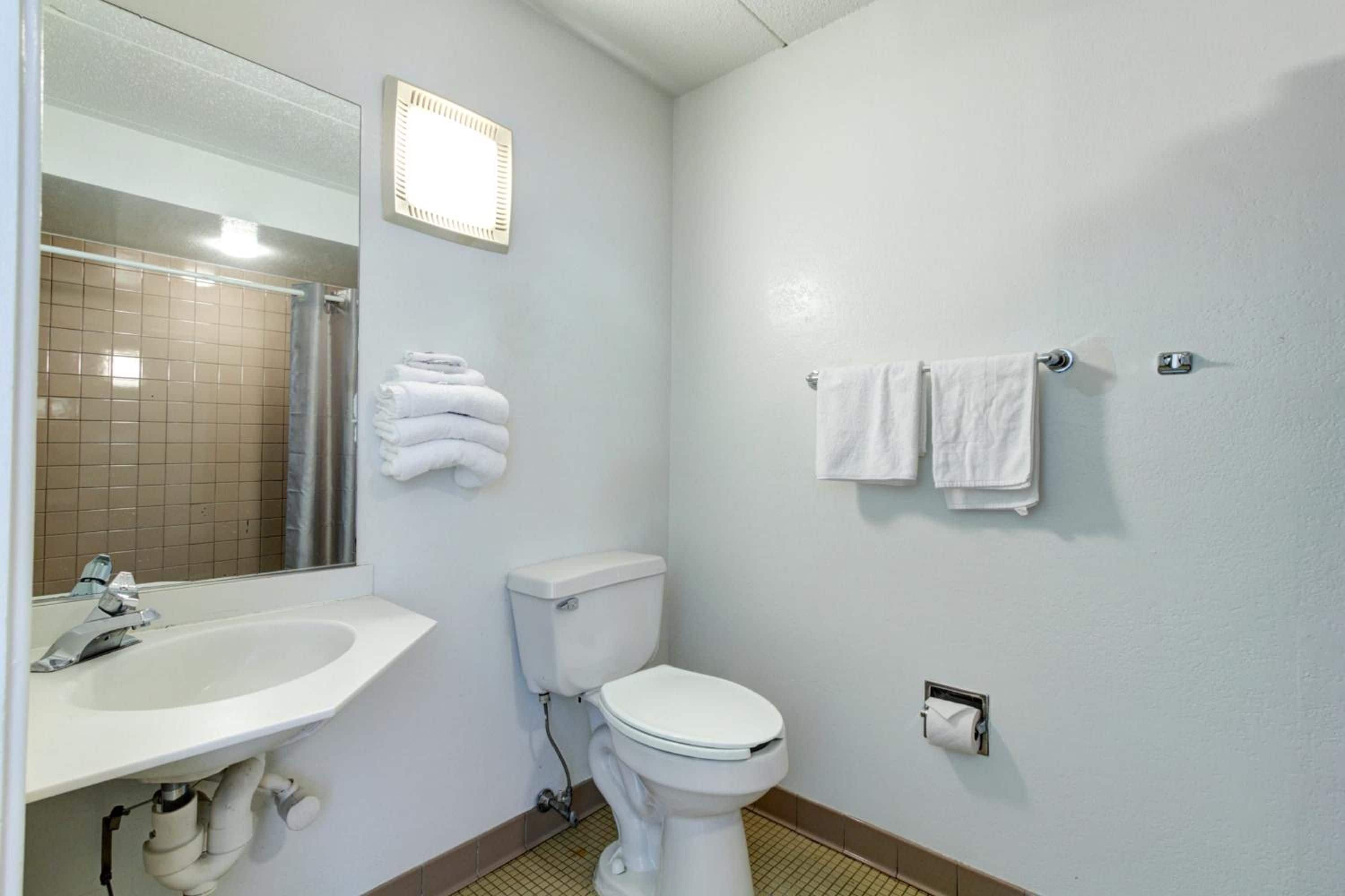 Une salle de bain équipée d’un lavabo, de toilettes et d’un porte-serviettes.