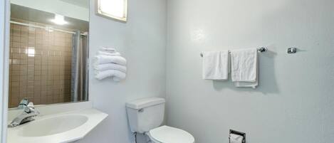 Une salle de bain équipée d’un lavabo, de toilettes et d’un porte-serviettes.