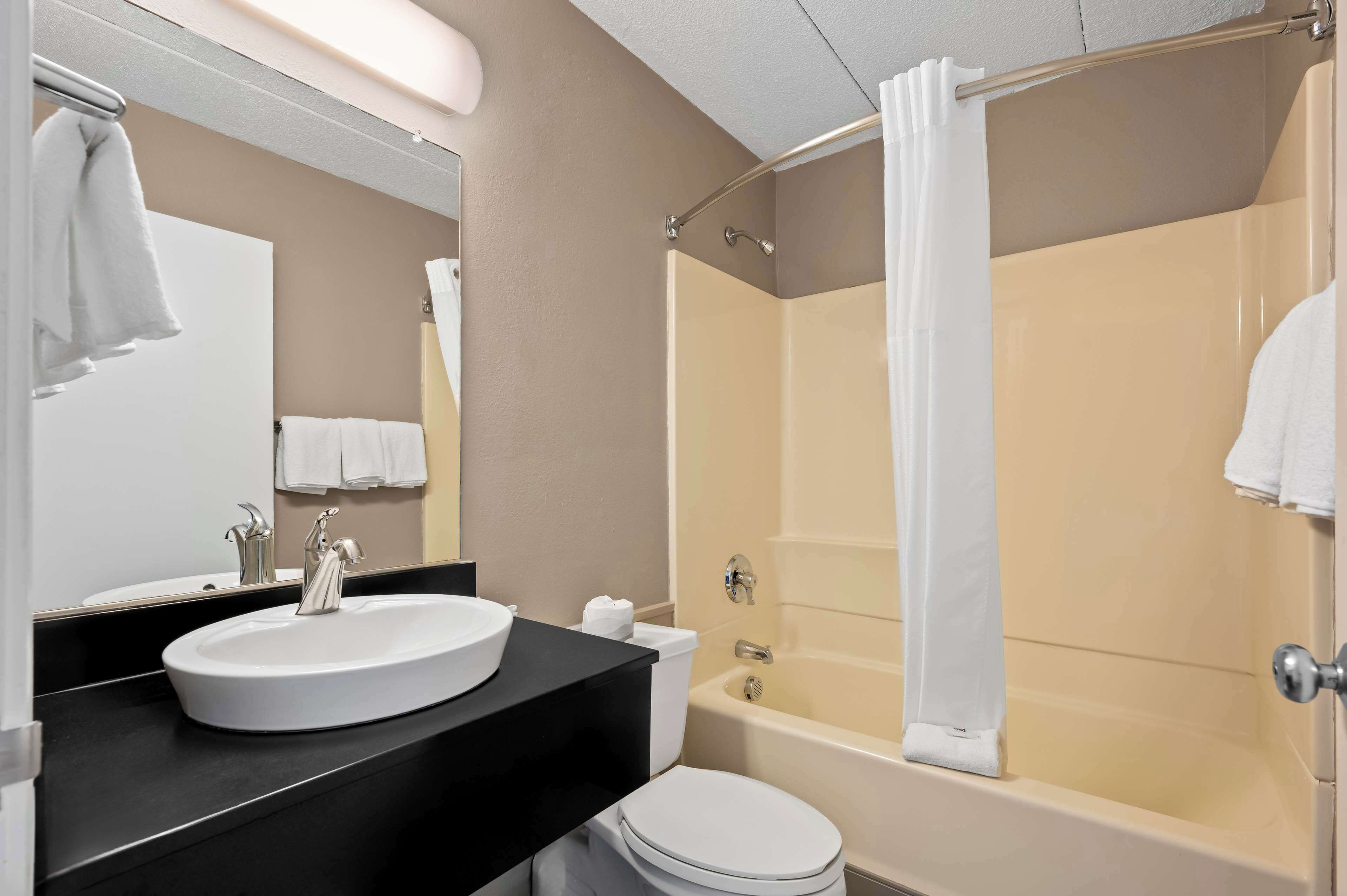 A bathroom with a sink, toilet, and bathtub.
