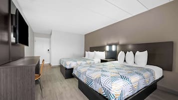 Habitación de hotel con dos camas, un escritorio, un televisor de pantalla plana y un diseño moderno.