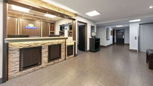 A reception area with a stone facade, a reception desk, and a sign for Days Inn. - Days Inn by Wyndham Fort Smith (Fort Smith)