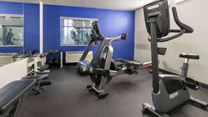 A gym with exercise equipment, a bench, and dumbbells. - Days Inn by Wyndham Fort Smith (Fort Smith)