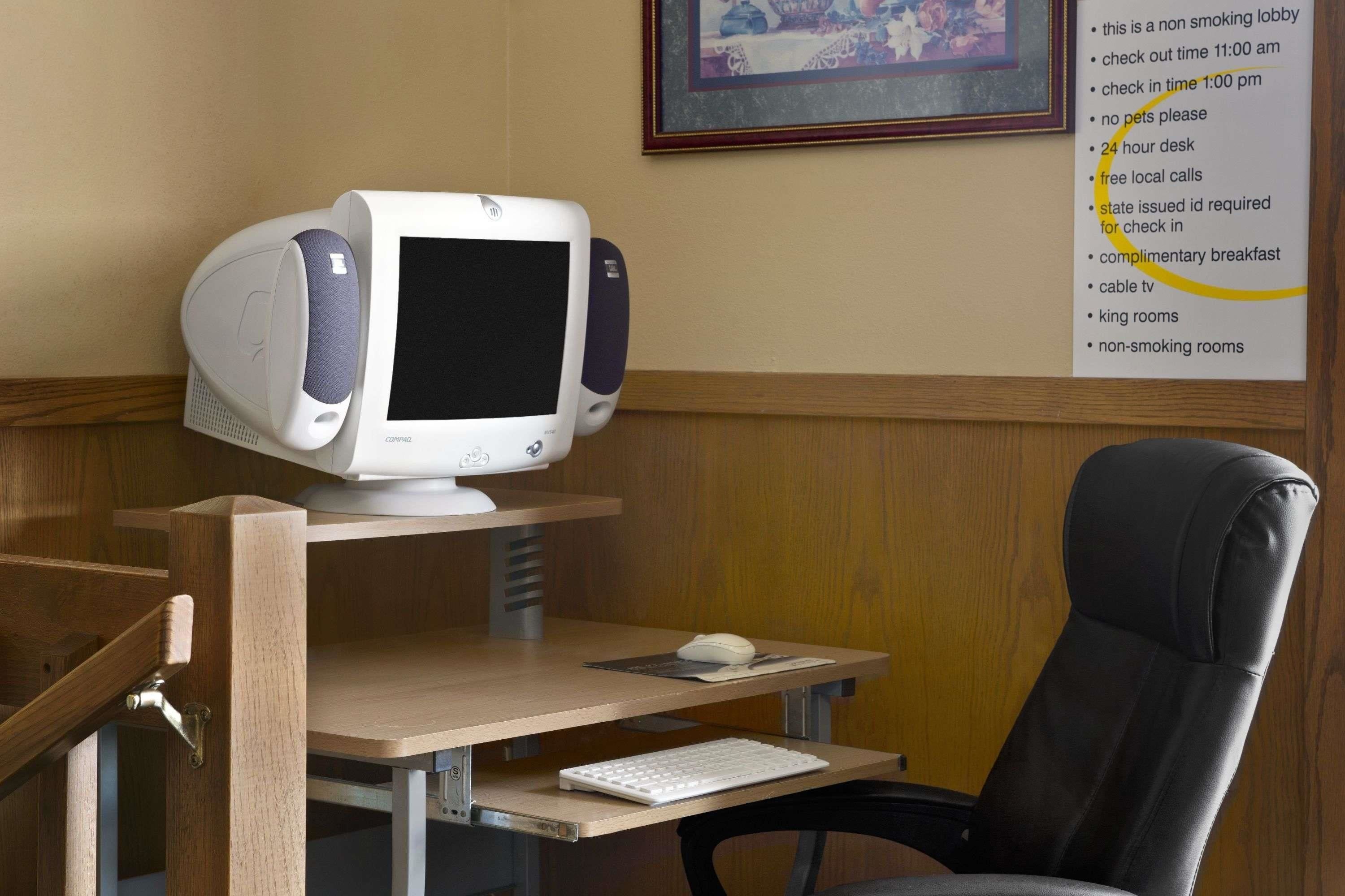 A computer desk with a desktop computer, a keyboard, a mouse, and a chair.