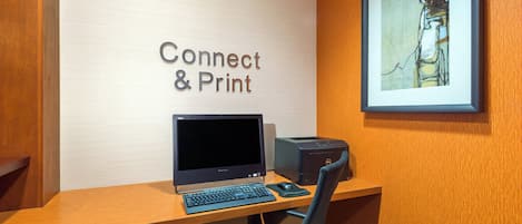 A workspace with a computer, keyboard, mouse, and printer on a wooden desk.