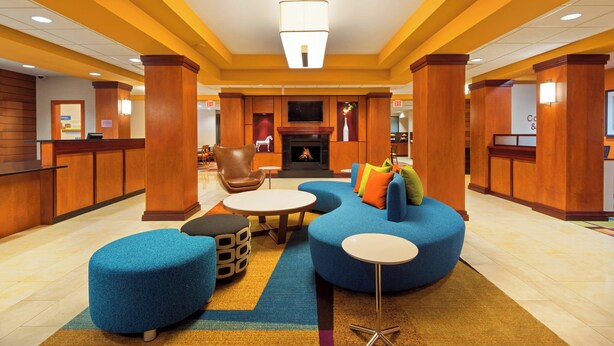 A lobby with a reception desk, seating area, and a fireplace.
