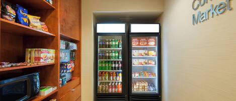 A corner market with shelves stocked with snacks, beverages, and condiments.