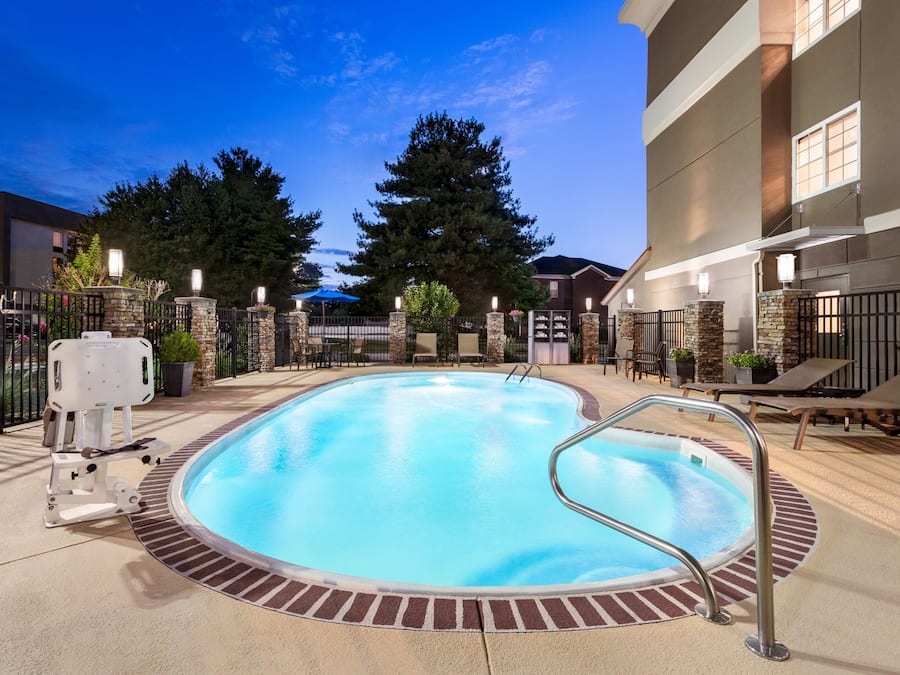 Een buitenzwembad, ligstoelen bij het zwembad