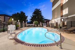 Una piscina al aire libre, sillones reclinables de piscina
