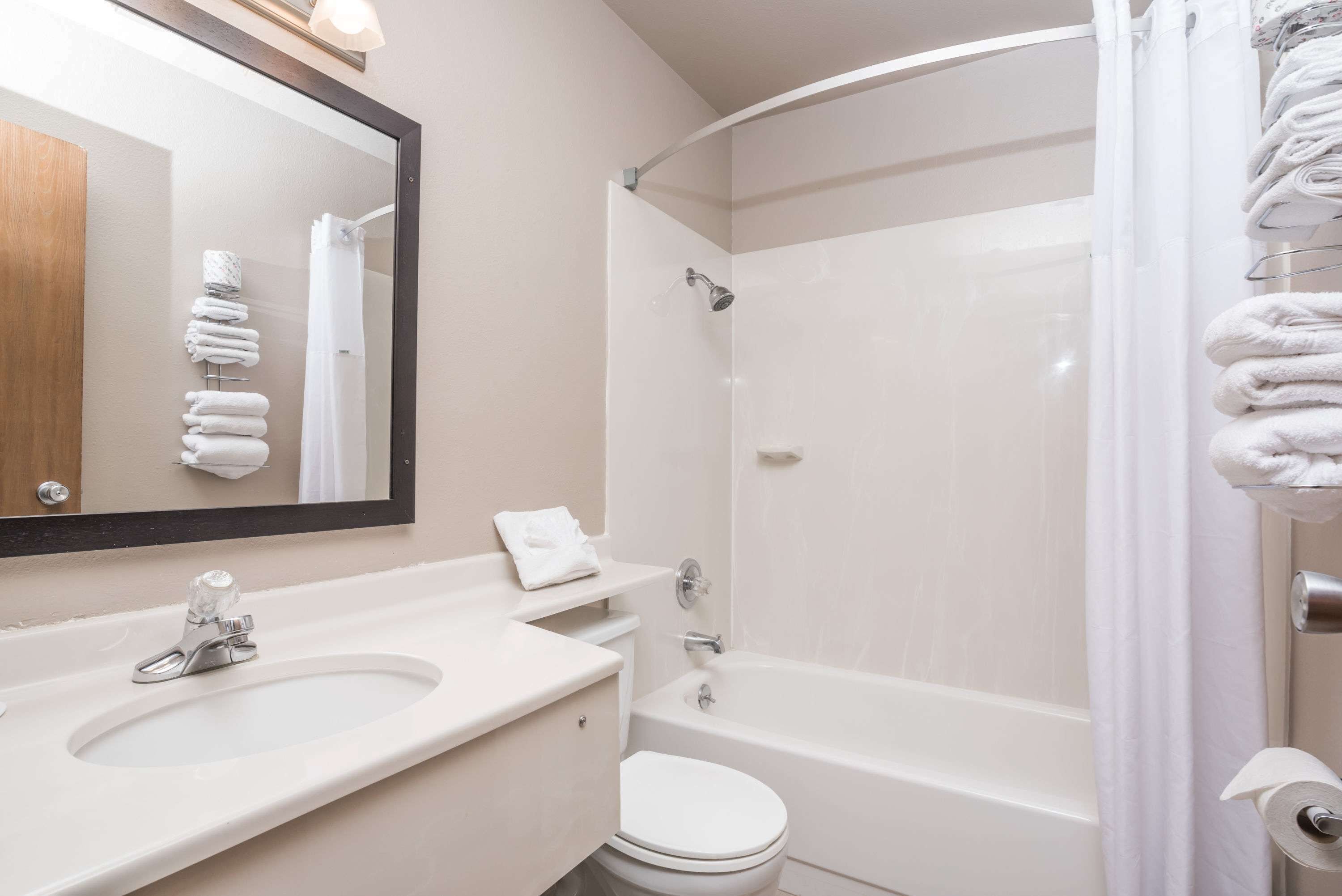 A modern bathroom with a sink, toilet, and bathtub.