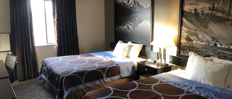 A hotel room with two beds, a desk, a chair, and a large window with curtains.