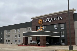 Un hotel La Quinta con diseño moderno, que presenta un logotipo destacado y una entrada cubierta.