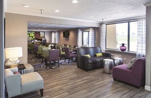 Un vestíbulo de hotel con zona de estar, bar y vistas al exterior.