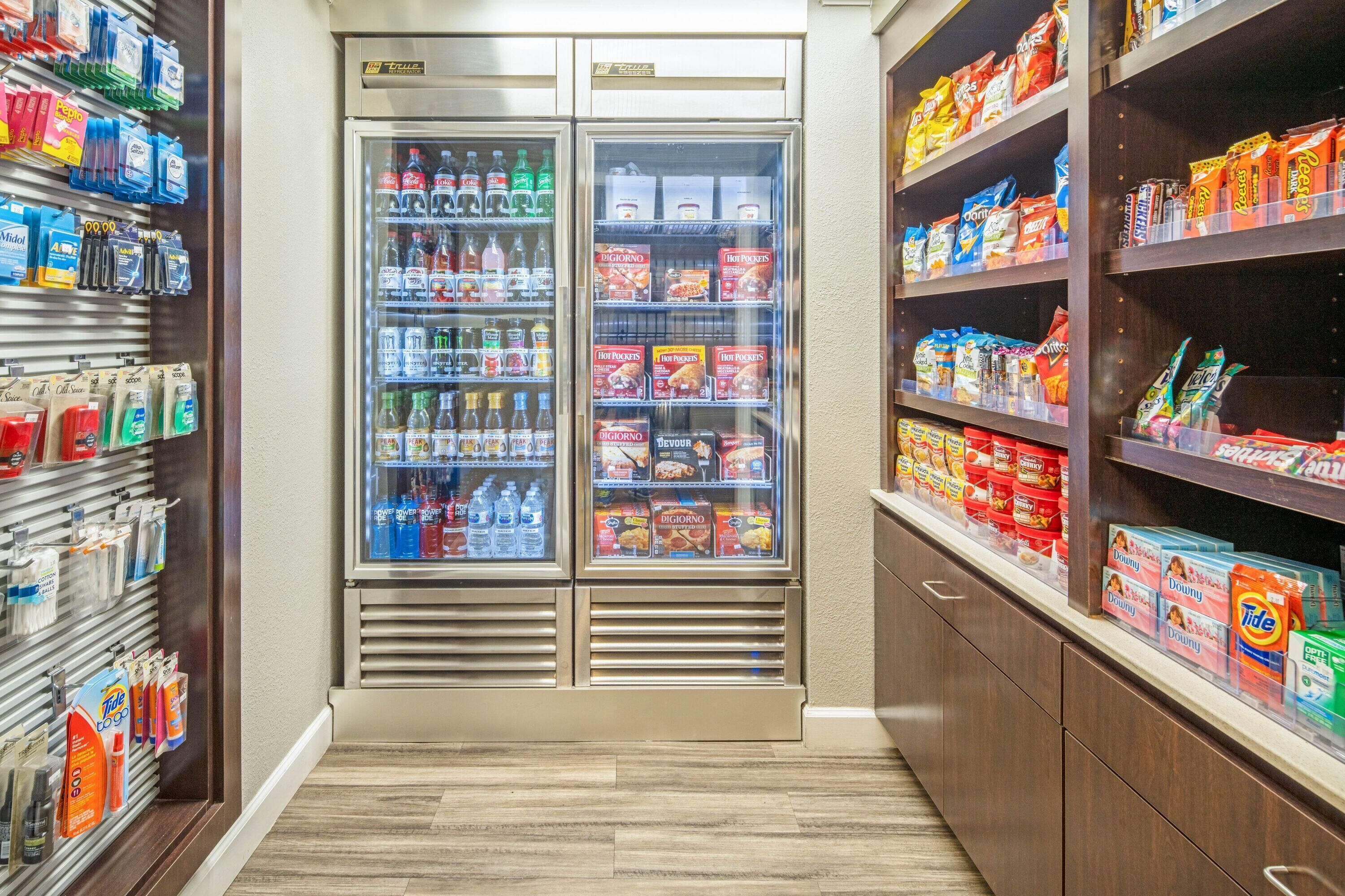 Un angolo dedicato a bevande e snack self-service, con frigoriferi e scaffali pieni di merendine.