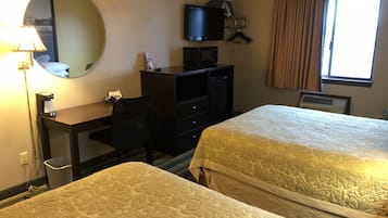 Habitación de hotel con dos camas, un escritorio, una silla, un televisor y una ventana con cortinas.