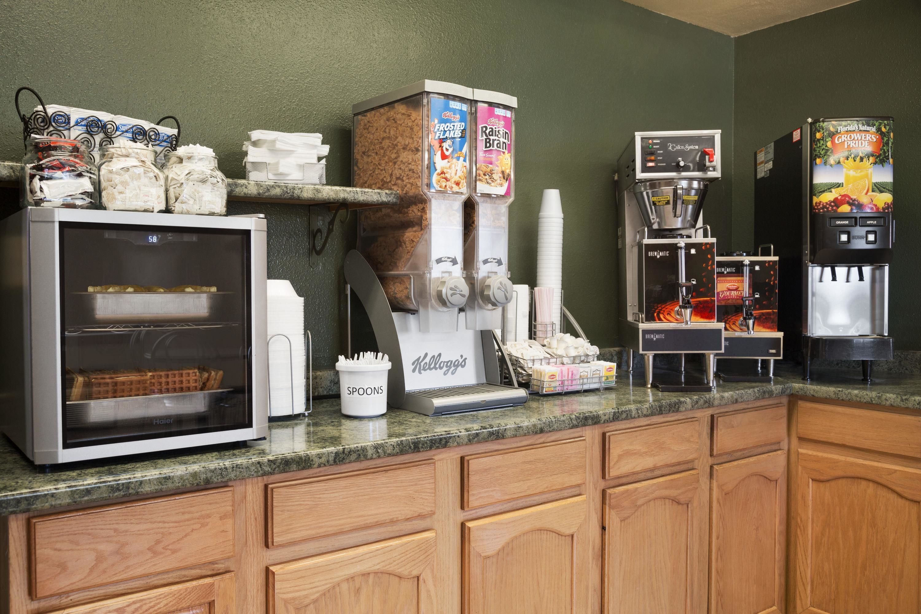 A self-service beverage station with multiple drink dispensers, including options for coffee, tea, and soft drinks.
